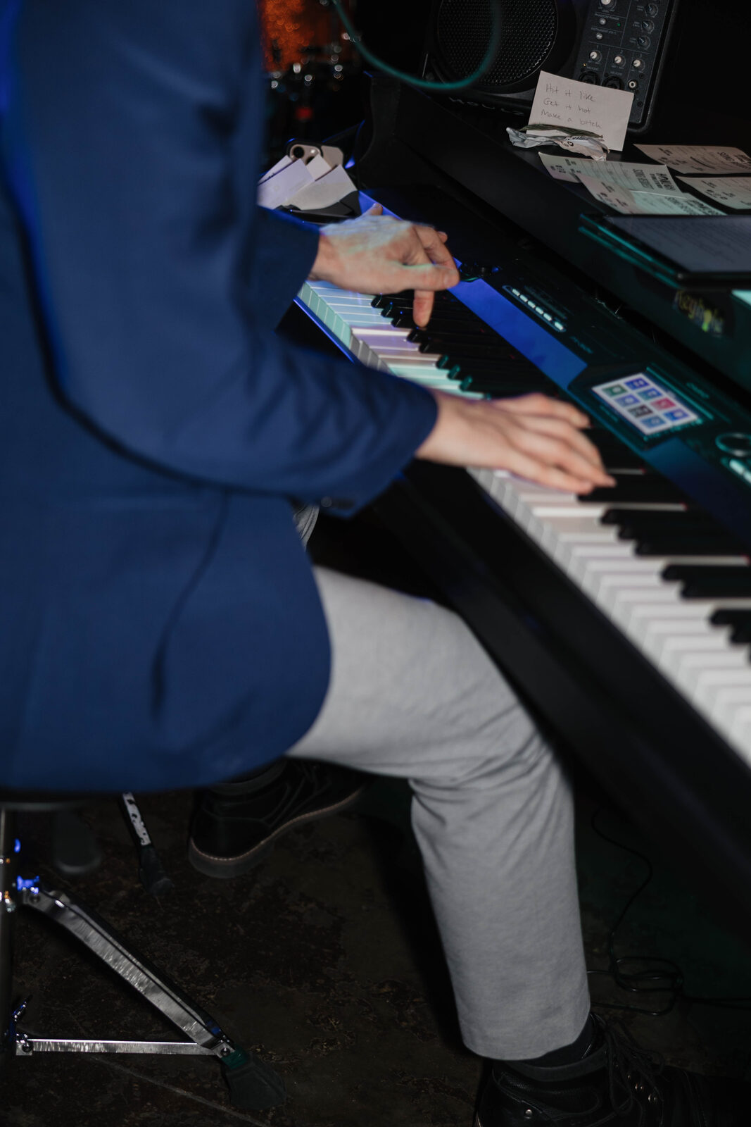 Close-up of a performer's hands playing keys at a Grandstand Dueling Pianos show