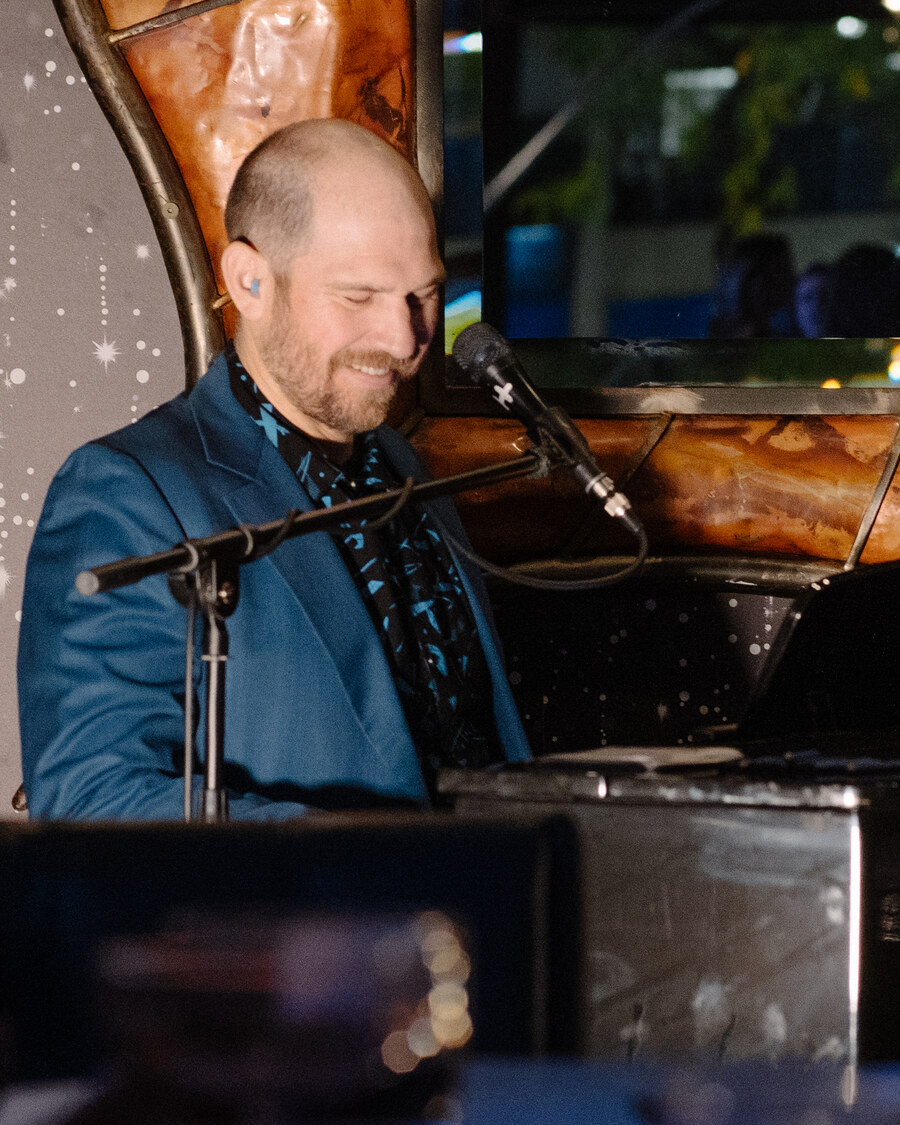 John Weston smiling while performing at the piano